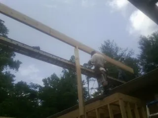 Carpenter setting a ridge beam over a new addition frame — Ice Dam Removal by Roofing Brothers in Williamstown